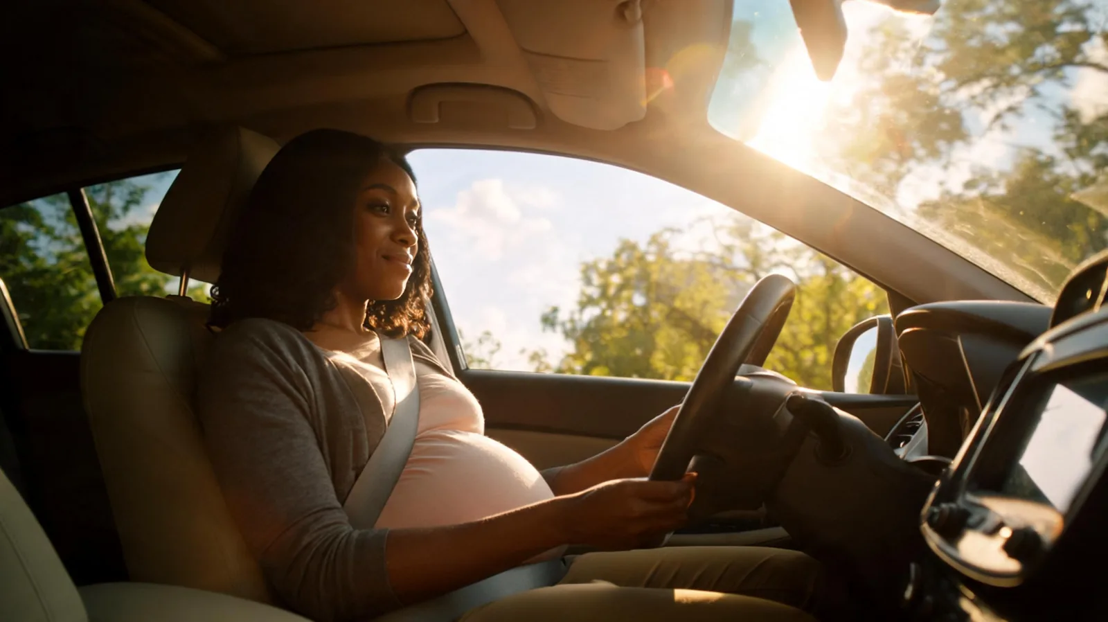 Femme enceinte au volant avec ceinture de securite bien positionnee sous le ventre
